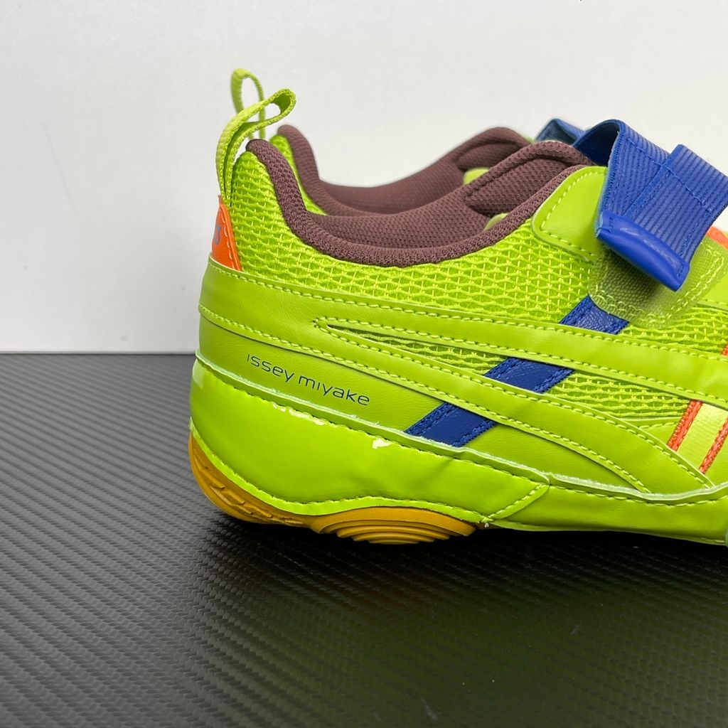 Side profile of the ASICS x Issey Miyake Hyper Taping sneaker in a sophisticated green tonal colorway, highlighting the unique, ribbon-like taping construction, sleek silhouette, and premium collaborative detailing.