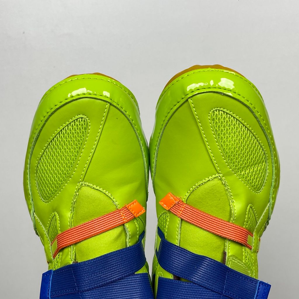 Side profile of the ASICS x Issey Miyake Hyper Taping sneaker in a sophisticated green tonal colorway, highlighting the unique, ribbon-like taping construction, sleek silhouette, and premium collaborative detailing.