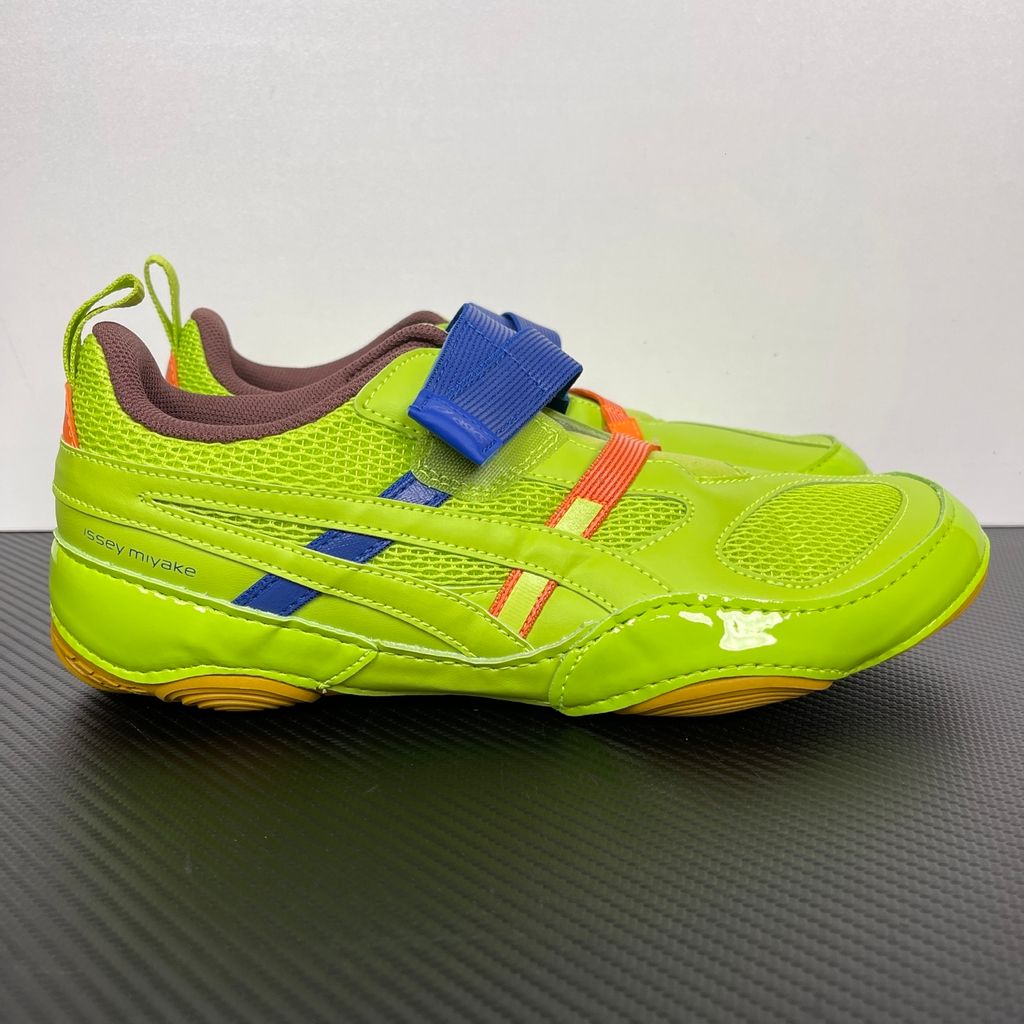 Side profile of the ASICS x Issey Miyake Hyper Taping sneaker in a sophisticated green tonal colorway, highlighting the unique, ribbon-like taping construction, sleek silhouette, and premium collaborative detailing.
