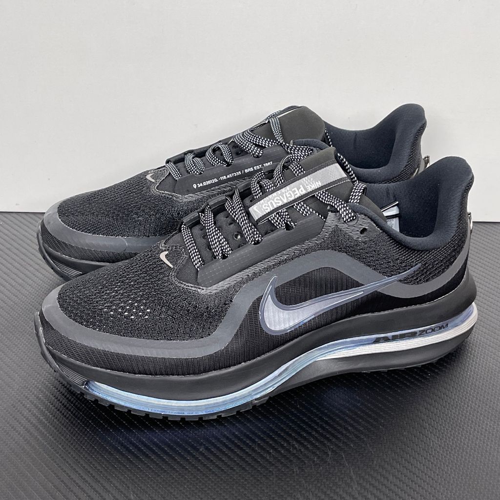 Side profile of the Nike Air Zoom Pegasus Premium sneaker in the 'Black Metallic Silver' colorway, showcasing the lightweight black engineered mesh upper, shimmering metallic silver Swoosh branding, and the sculpted, responsive midsole.