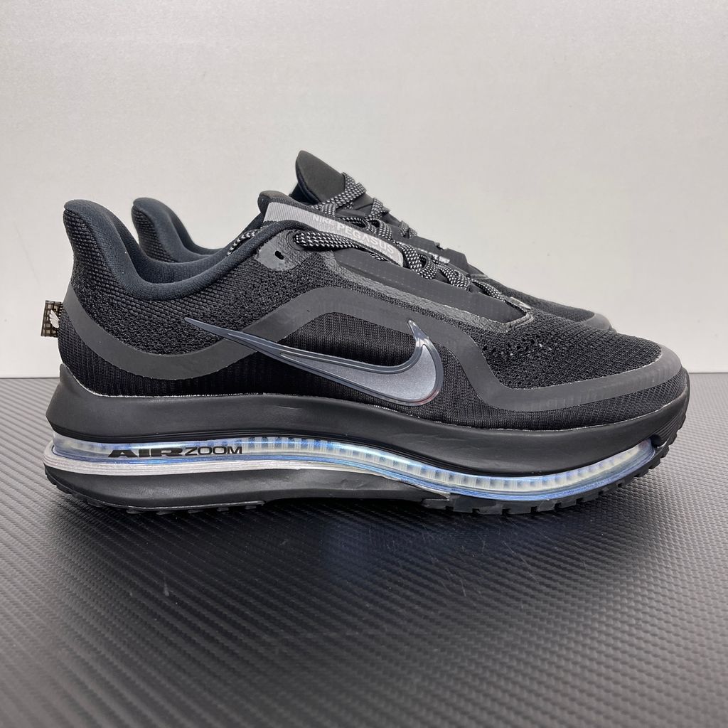 Side profile of the Nike Air Zoom Pegasus Premium sneaker in the 'Black Metallic Silver' colorway, showcasing the lightweight black engineered mesh upper, shimmering metallic silver Swoosh branding, and the sculpted, responsive midsole.