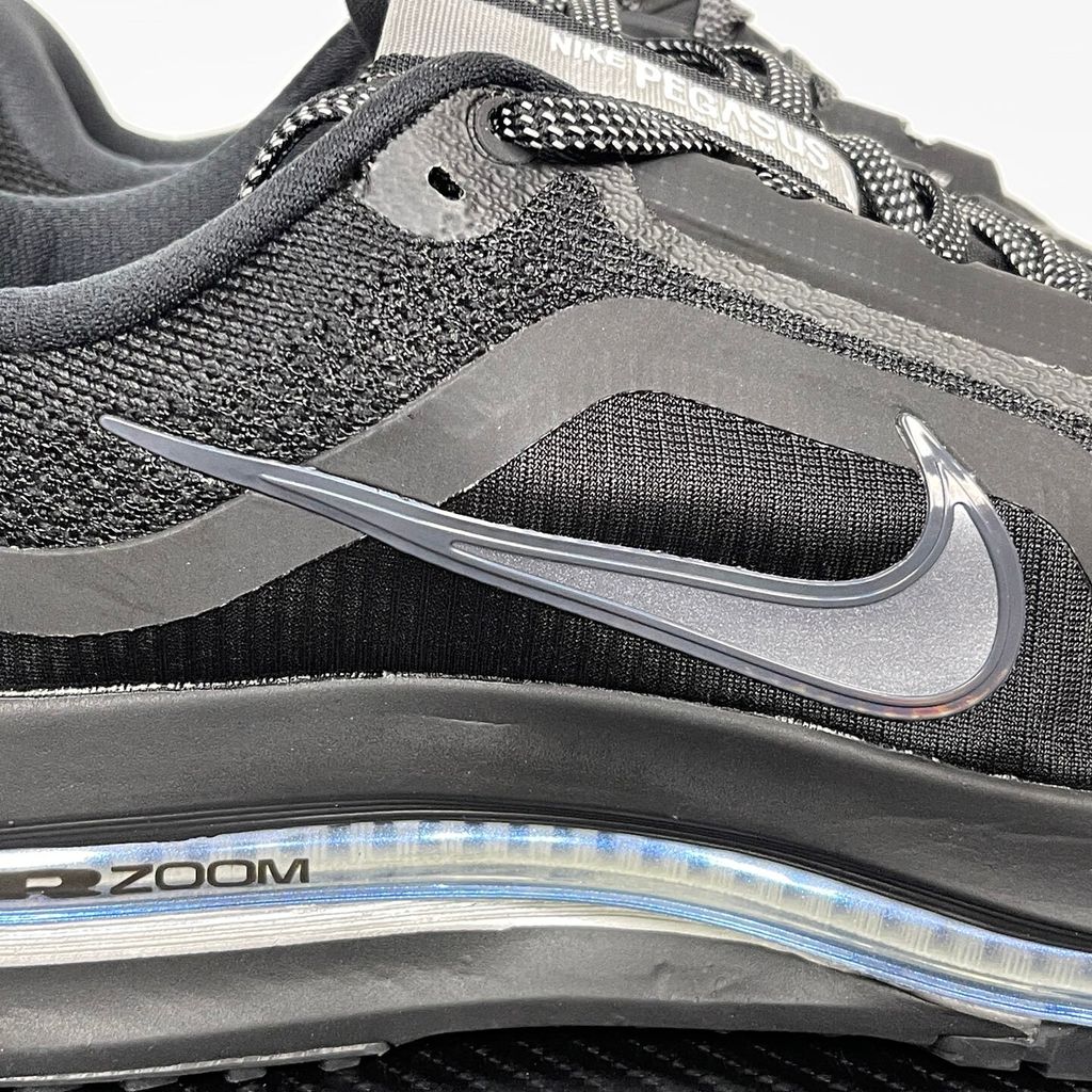 Side profile of the Nike Air Zoom Pegasus Premium sneaker in the 'Black Metallic Silver' colorway, showcasing the lightweight black engineered mesh upper, shimmering metallic silver Swoosh branding, and the sculpted, responsive midsole.