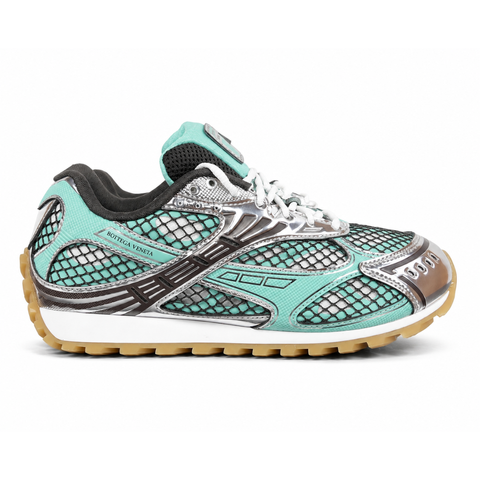 Side profile of the Bottega Veneta Orbit Sneaker, highlighting the vibrant Green Oasis and metallic silver colorway, technical fishnet mesh paneling, and the distinct, rugged rubber outsole.