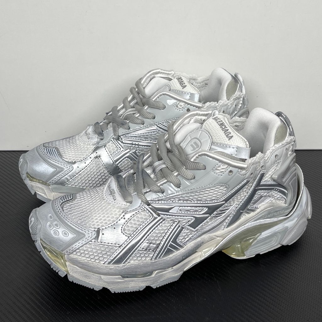 Side profile of the Balenciaga Runner sneaker in the 'White Silver' colorway, highlighting the complex multi-layered construction, distressed technical mesh and synthetic overlays, and the iconic dynamic sole unit.