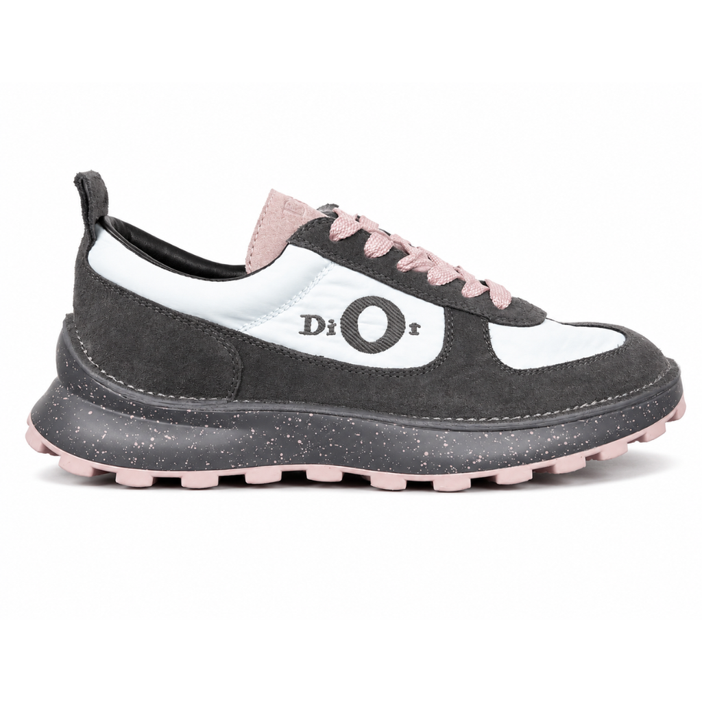 Side profile of the Dior Squash sneaker, highlighting the contrasting dark grey suede and light blue nylon upper, the unique 'DIOR' circular logo embroidery, and the speckled polyurethane midsole with a lugged outsole.