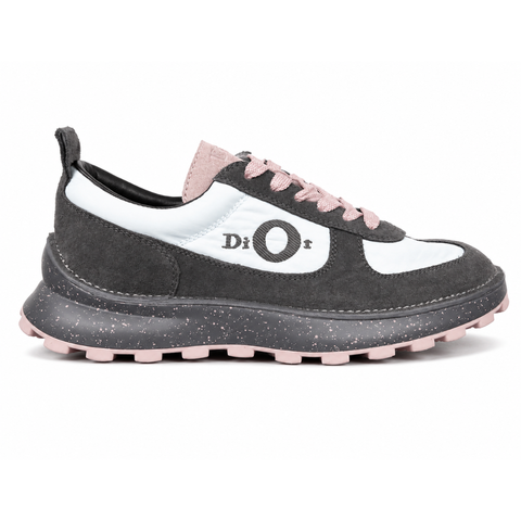 Side profile of the Dior Squash sneaker, highlighting the contrasting dark grey suede and light blue nylon upper, the unique 'DIOR' circular logo embroidery, and the speckled polyurethane midsole with a lugged outsole.