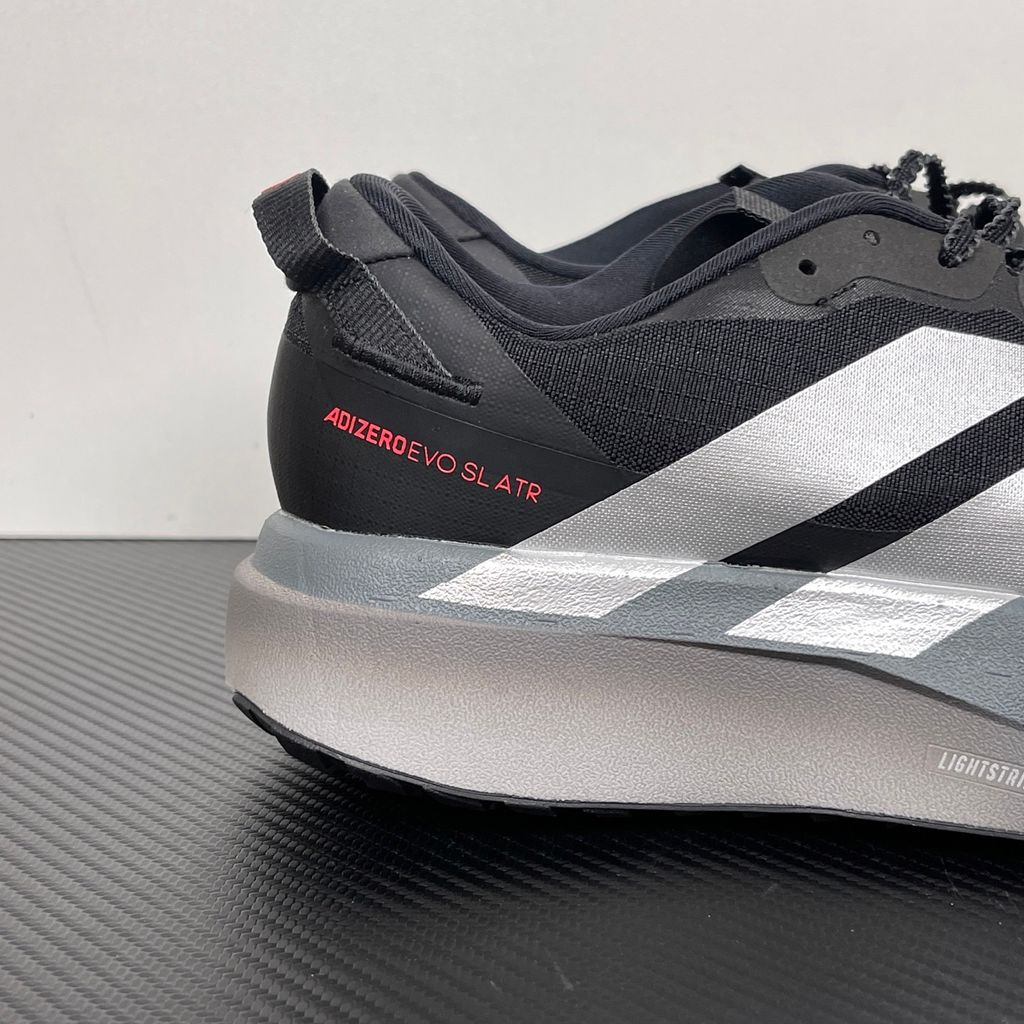 Side profile of the adidas Adizero Evo SL running shoe in the 'ATROnix Grey Black' colorway, showcasing the ultra-lightweight breathable mesh upper, sleek aerodynamic profile, and the sculpted Lightstrike Pro foam midsole.