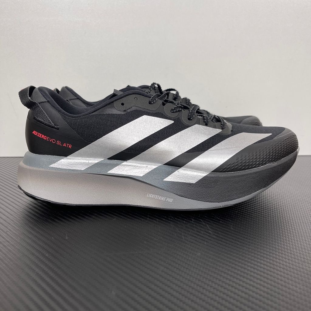 Side profile of the adidas Adizero Evo SL running shoe in the 'ATROnix Grey Black' colorway, showcasing the ultra-lightweight breathable mesh upper, sleek aerodynamic profile, and the sculpted Lightstrike Pro foam midsole.