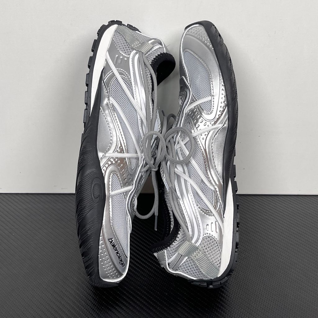Side profile of the Balenciaga Radar Sneaker featuring a metallic silver and grey mesh upper, intricate gradient line overlays, a classic lace-up system, and a sleek, low-profile black rubber outsole.