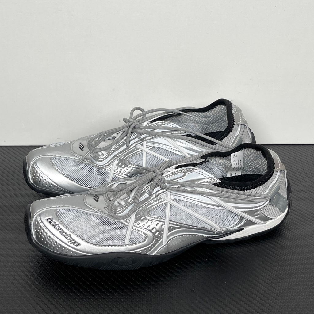 Side profile of the Balenciaga Radar Sneaker featuring a metallic silver and grey mesh upper, intricate gradient line overlays, a classic lace-up system, and a sleek, low-profile black rubber outsole.
