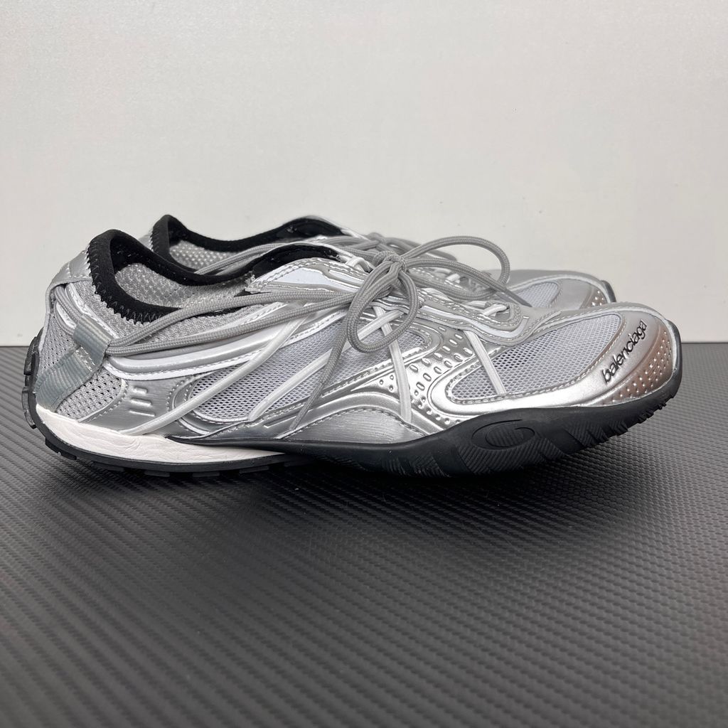 Side profile of the Balenciaga Radar Sneaker featuring a metallic silver and grey mesh upper, intricate gradient line overlays, a classic lace-up system, and a sleek, low-profile black rubber outsole.