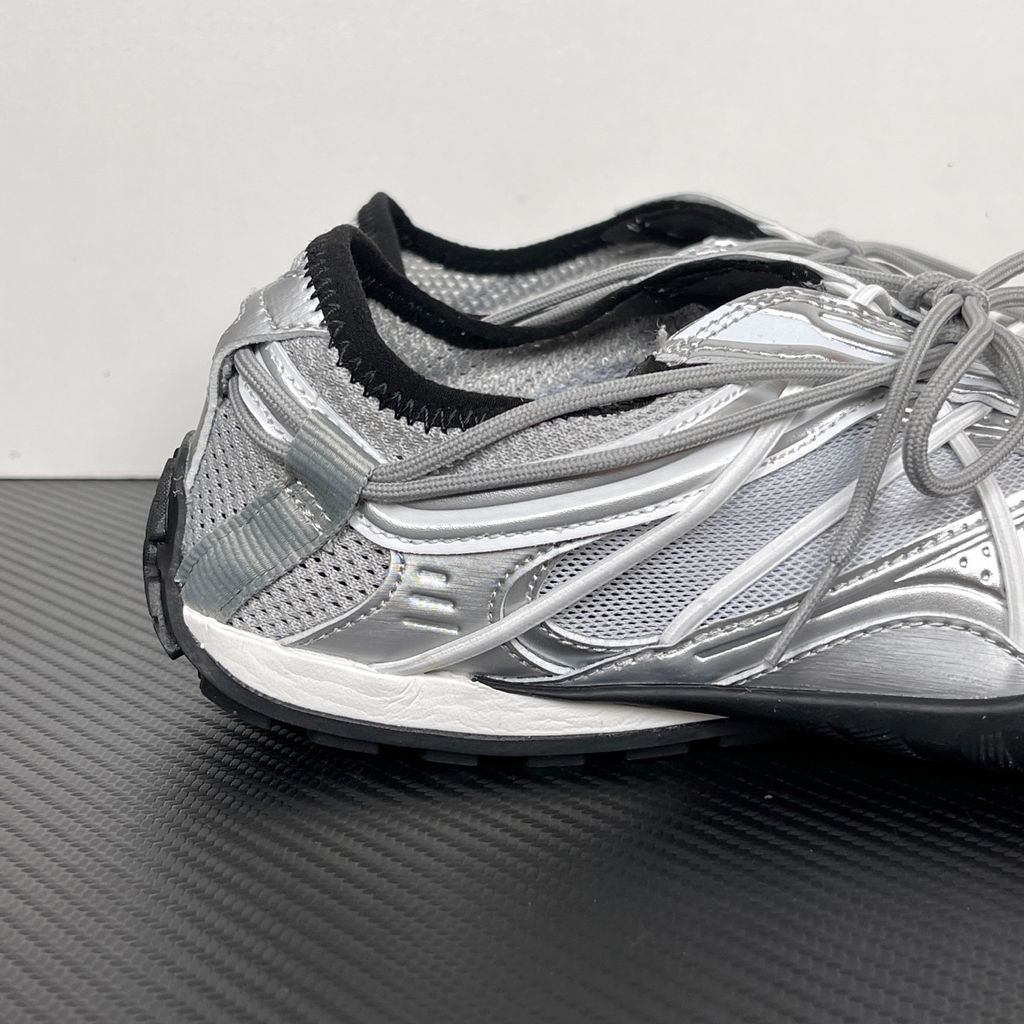 Side profile of the Balenciaga Radar Sneaker featuring a metallic silver and grey mesh upper, intricate gradient line overlays, a classic lace-up system, and a sleek, low-profile black rubber outsole.
