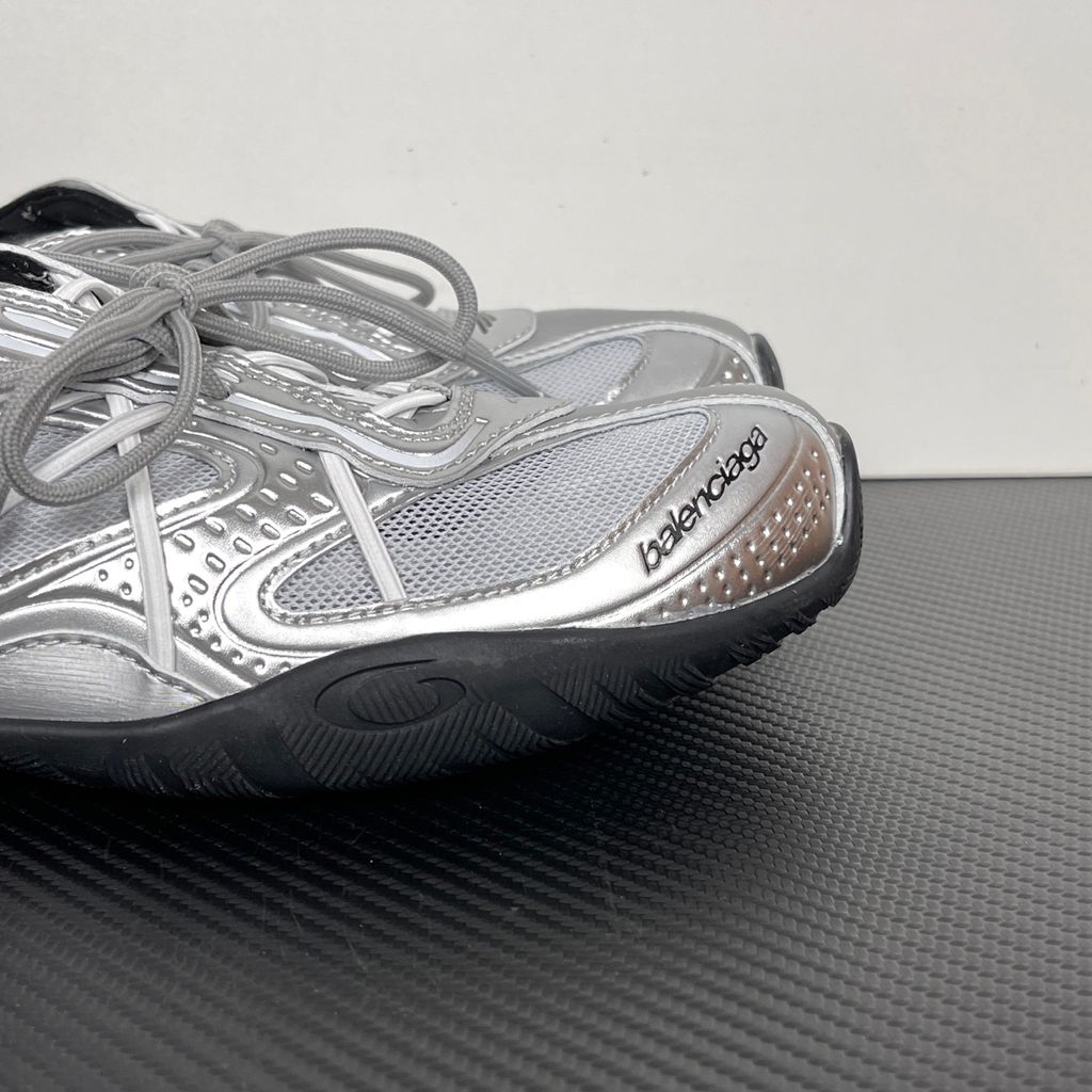 Side profile of the Balenciaga Radar Sneaker featuring a metallic silver and grey mesh upper, intricate gradient line overlays, a classic lace-up system, and a sleek, low-profile black rubber outsole.