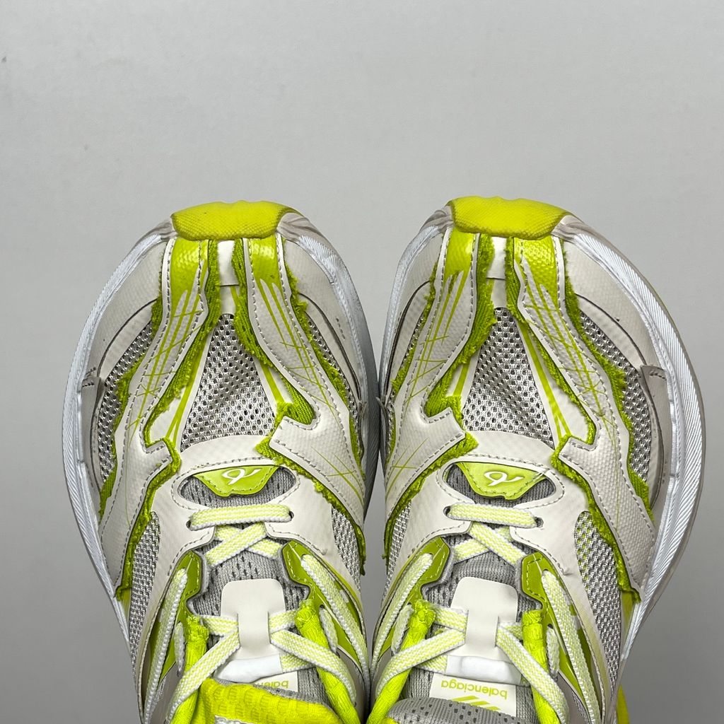 Side profile of the Balenciaga Jet Sneaker highlighting the eggshell white and vibrant light lime green upper, heavily distressed mesh detailing, embossed branding, and the signature 4.25cm exaggerated platform sole.
