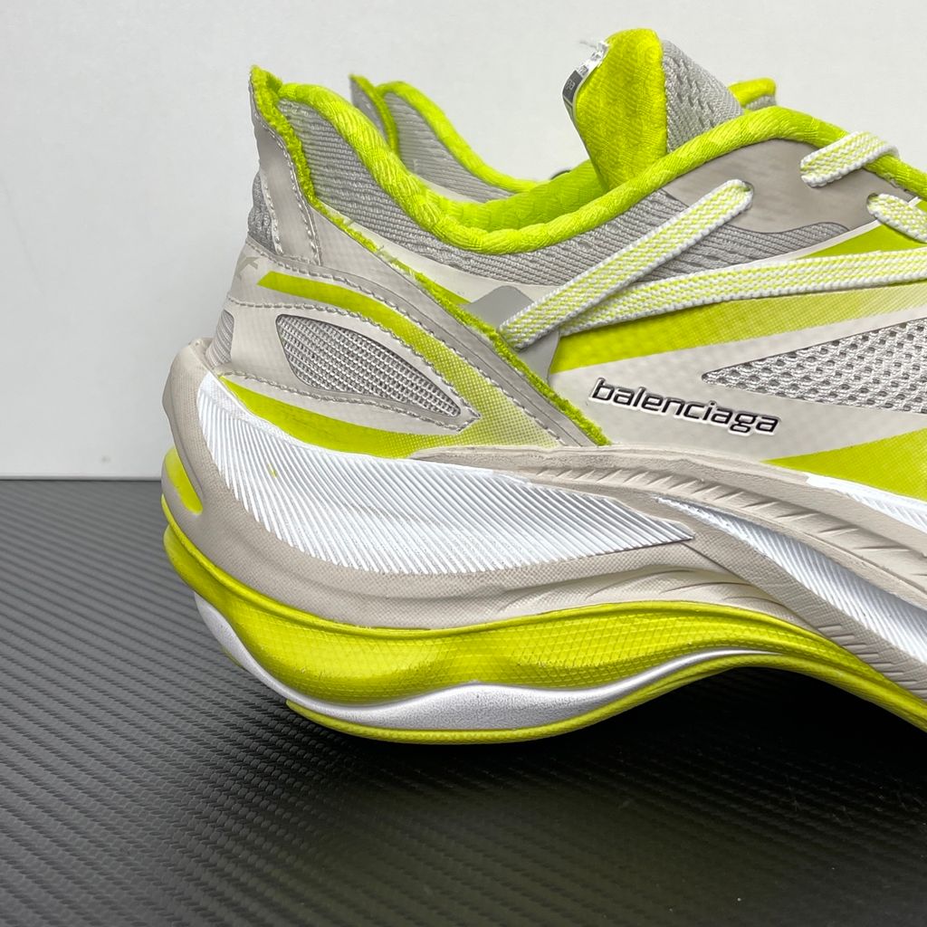Side profile of the Balenciaga Jet Sneaker highlighting the eggshell white and vibrant light lime green upper, heavily distressed mesh detailing, embossed branding, and the signature 4.25cm exaggerated platform sole.