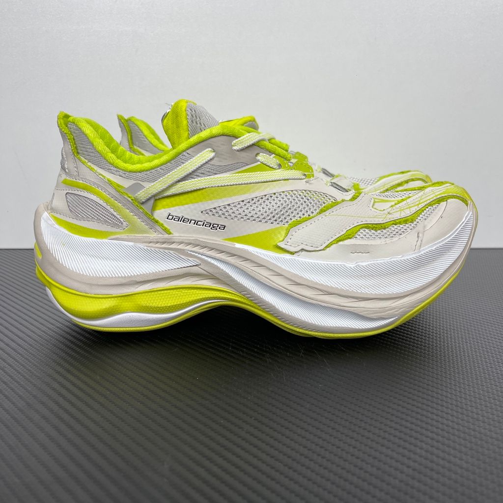 Side profile of the Balenciaga Jet Sneaker highlighting the eggshell white and vibrant light lime green upper, heavily distressed mesh detailing, embossed branding, and the signature 4.25cm exaggerated platform sole.
