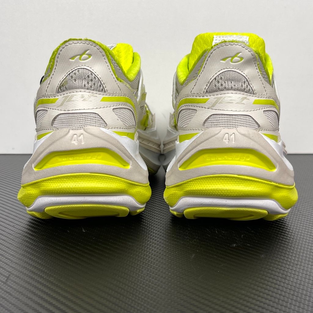 Side profile of the Balenciaga Jet Sneaker highlighting the eggshell white and vibrant light lime green upper, heavily distressed mesh detailing, embossed branding, and the signature 4.25cm exaggerated platform sole.