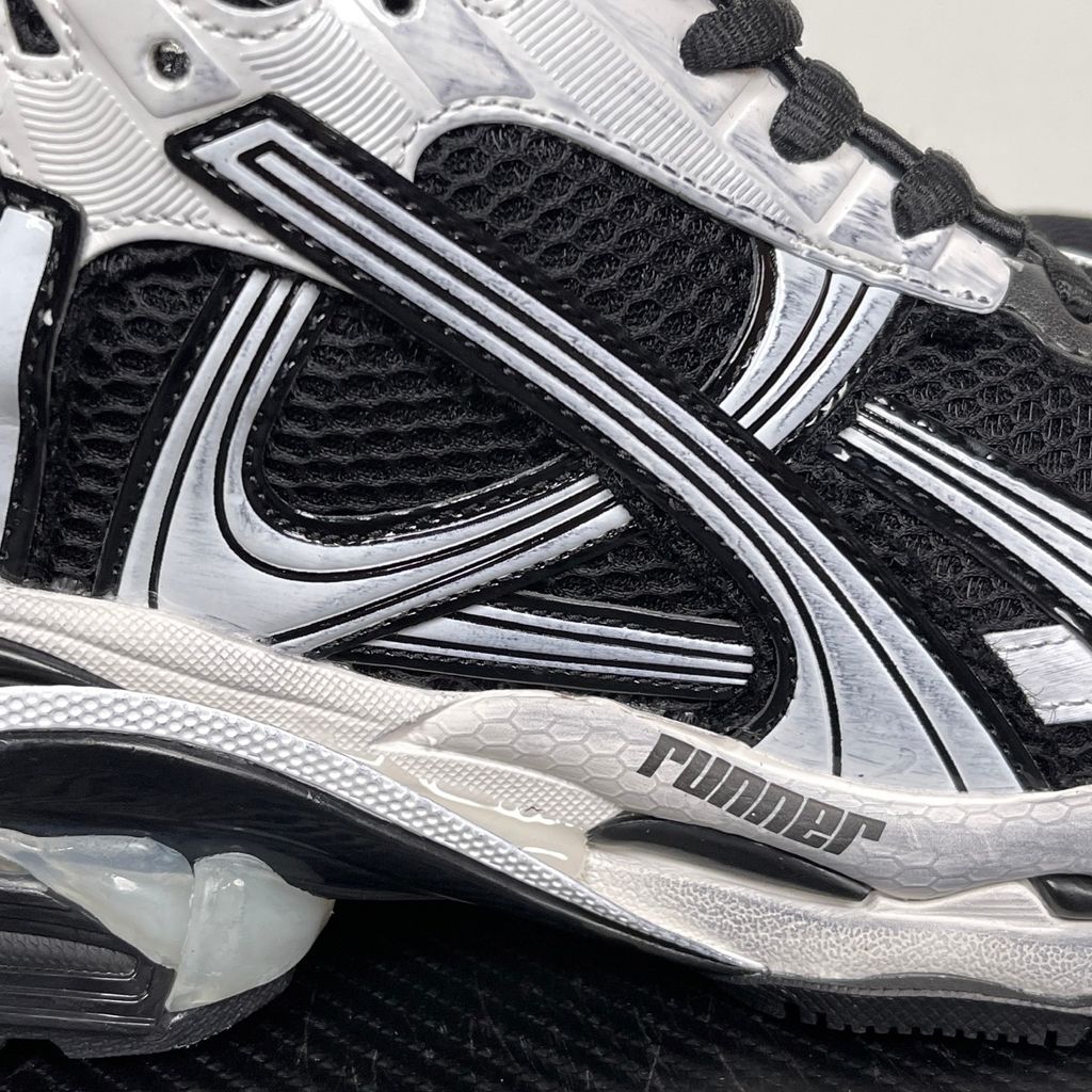 Side profile of the Balenciaga Runner LED sneaker in the 'Black/White' colorway, highlighting the intricate multi-layered mesh and synthetic construction, high-contrast paneling, and the clear heel capsule housing the LED technology.