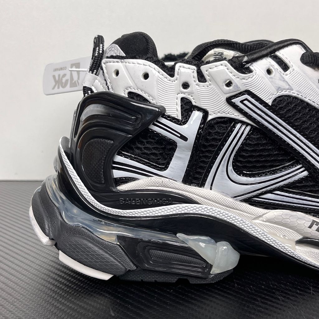 Side profile of the Balenciaga Runner LED sneaker in the 'Black/White' colorway, highlighting the intricate multi-layered mesh and synthetic construction, high-contrast paneling, and the clear heel capsule housing the LED technology.