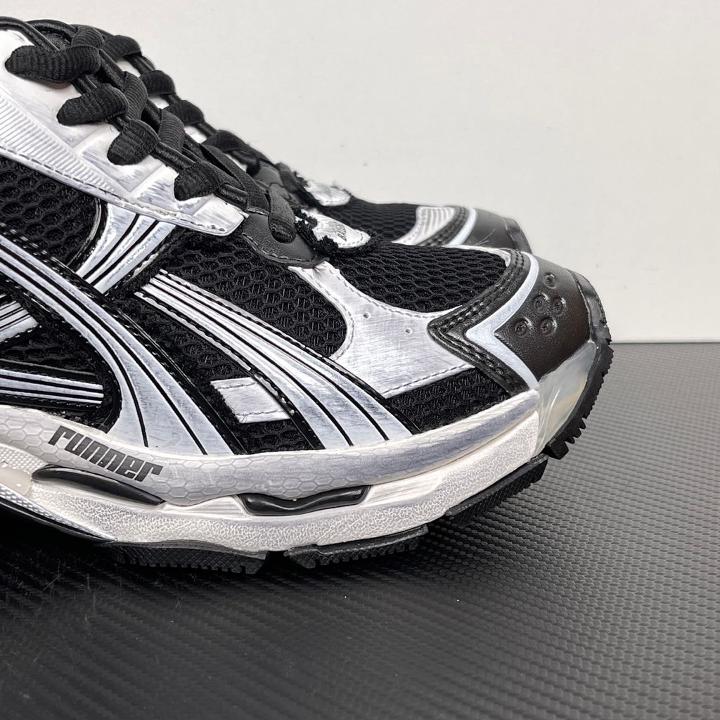Side profile of the Balenciaga Runner LED sneaker in the 'Black/White' colorway, highlighting the intricate multi-layered mesh and synthetic construction, high-contrast paneling, and the clear heel capsule housing the LED technology.