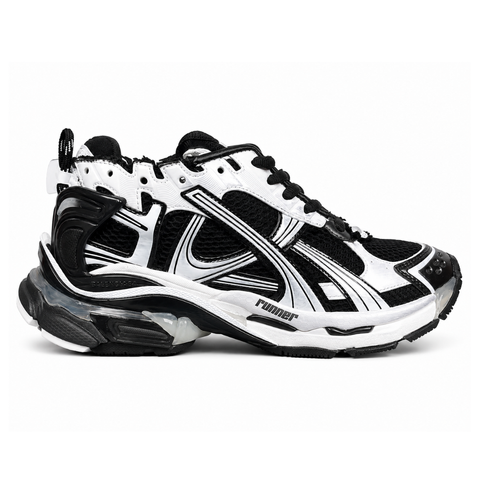 Side profile of the Balenciaga Runner LED sneaker in the 'Black/White' colorway, highlighting the intricate multi-layered mesh and synthetic construction, high-contrast paneling, and the clear heel capsule housing the LED technology.