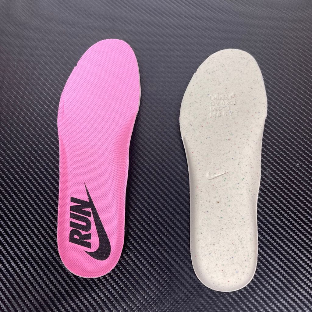 Side profile of the Nike Women's Vomero Plus running shoe, featuring a vibrant pink and purple engineered mesh upper, a metallic dark grey Swoosh, and a heavily cushioned, sculpted pink ZoomX foam midsole.