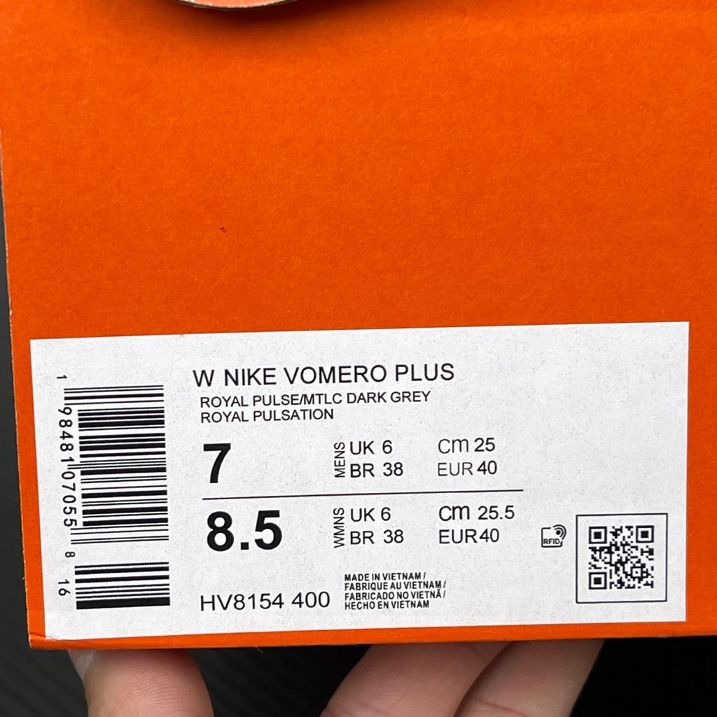 Side profile of the Nike Women's Vomero Plus running shoe, featuring a vibrant pink and purple engineered mesh upper, a metallic dark grey Swoosh, and a heavily cushioned, sculpted pink ZoomX foam midsole.