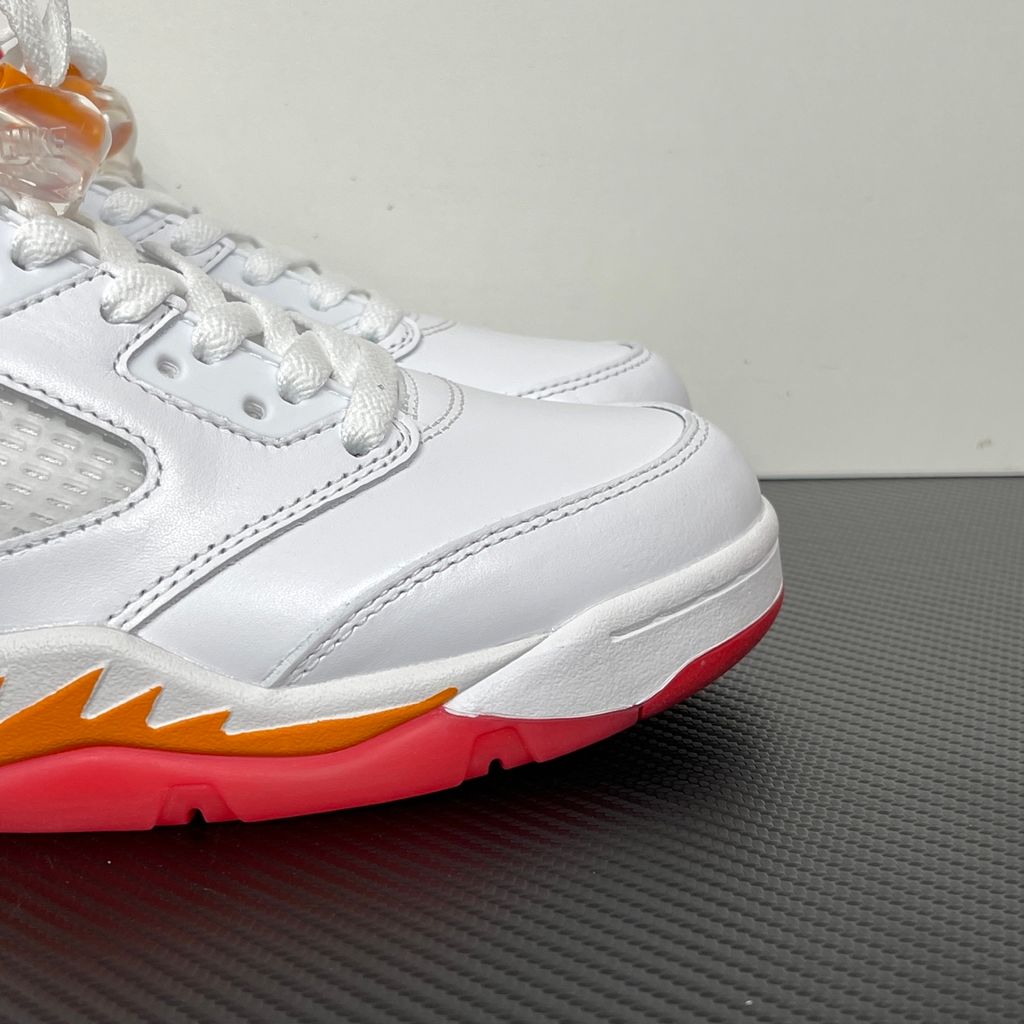 Side profile of the Air Jordan 5 Retro sneaker in the 'Sunset' colorway, featuring a crisp leather upper, vibrant orange and red sunset gradient accents, signature translucent netting, and the iconic shark tooth midsole detailing.
