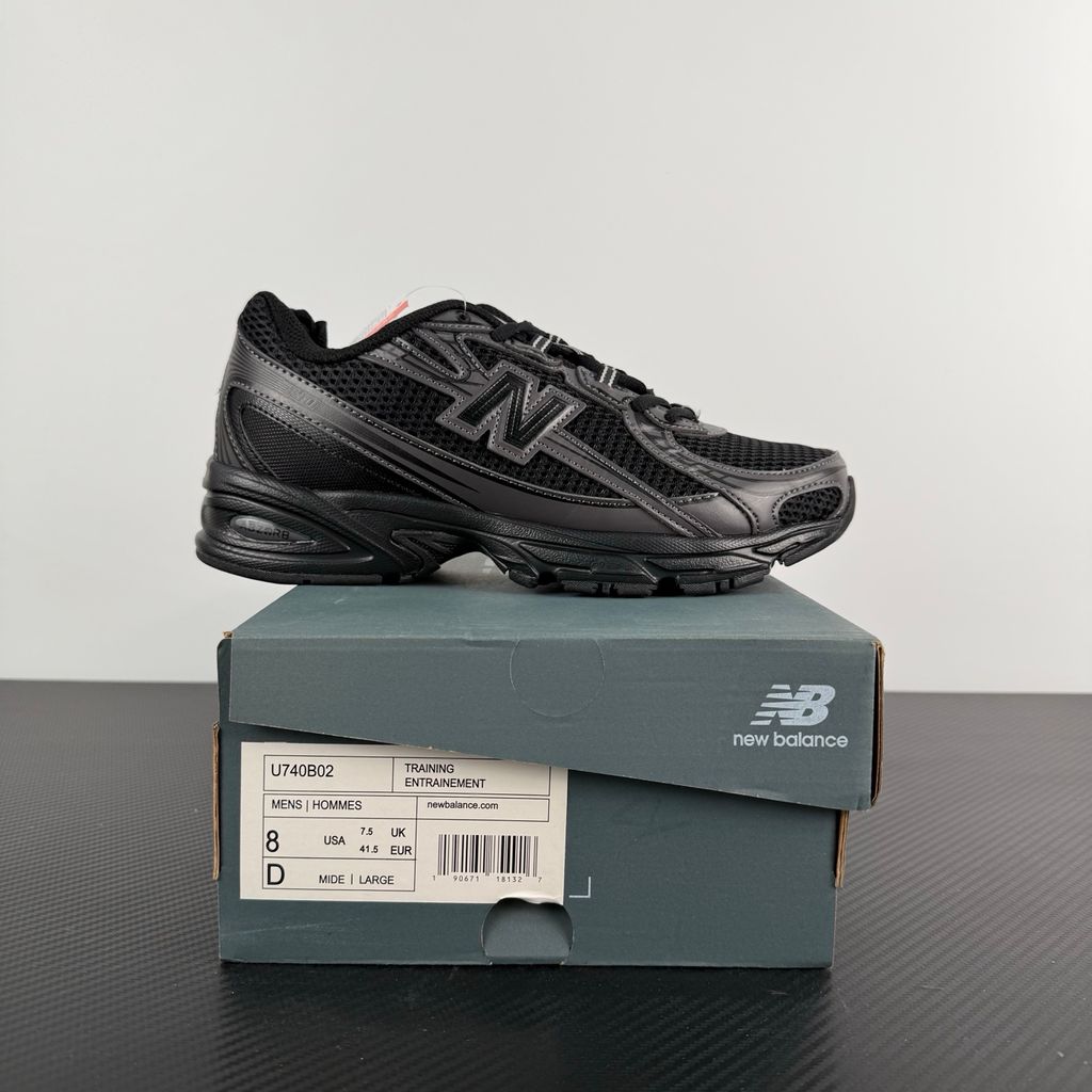 Side profile of the New Balance 740 sneaker in the 'Triple Black' colorway, showcasing the monochromatic mesh and synthetic upper, the tonal 'N' side logo, and the sculpted black midsole.