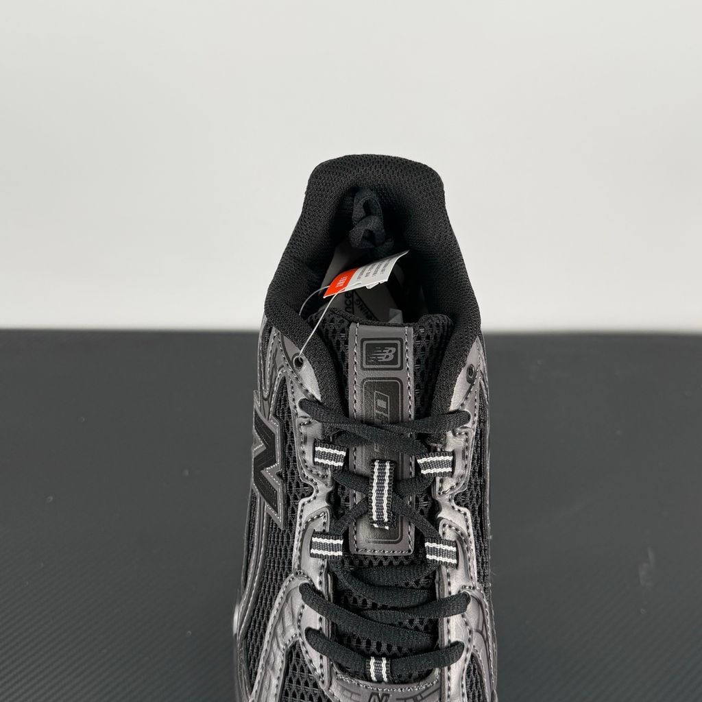 Side profile of the New Balance 740 sneaker in the 'Triple Black' colorway, showcasing the monochromatic mesh and synthetic upper, the tonal 'N' side logo, and the sculpted black midsole.