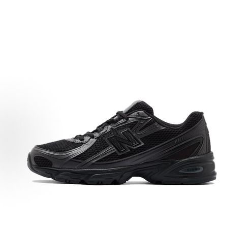 Side profile of the New Balance 740 sneaker in the 'Triple Black' colorway, showcasing the monochromatic mesh and synthetic upper, the tonal 'N' side logo, and the sculpted black midsole.