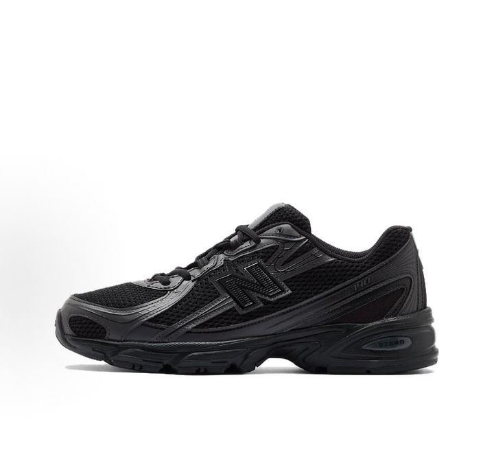 Side profile of the New Balance 740 sneaker in the 'Triple Black' colorway, showcasing the monochromatic mesh and synthetic upper, the tonal 'N' side logo, and the sculpted black midsole.