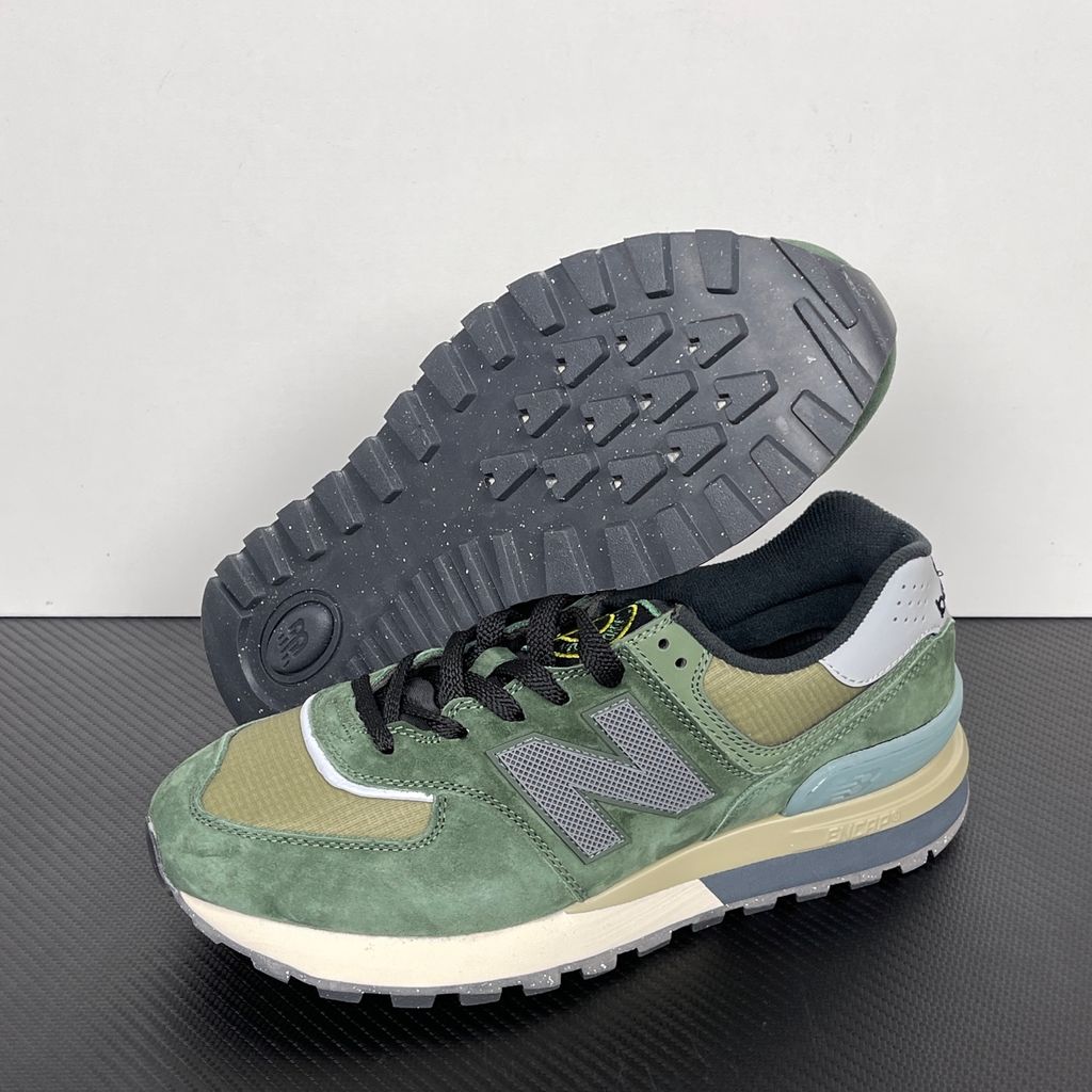 Side profile of the New Balance 574 Legacy Stone Island sneaker featuring a tactical dark green ripstop and suede upper, the iconic Stone Island compass logo on the tongue, and a rugged grey ENCAP midsole.