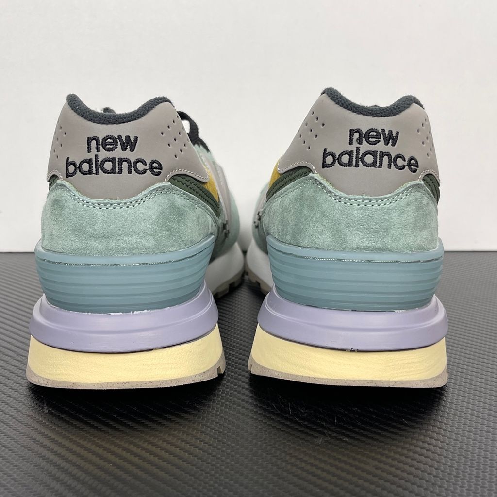 Side profile of the New Balance 574 Legacy Stone Island sneaker featuring a tactical light green ripstop and suede upper, the iconic Stone Island compass logo on the tongue, and a rugged grey ENCAP midsole.