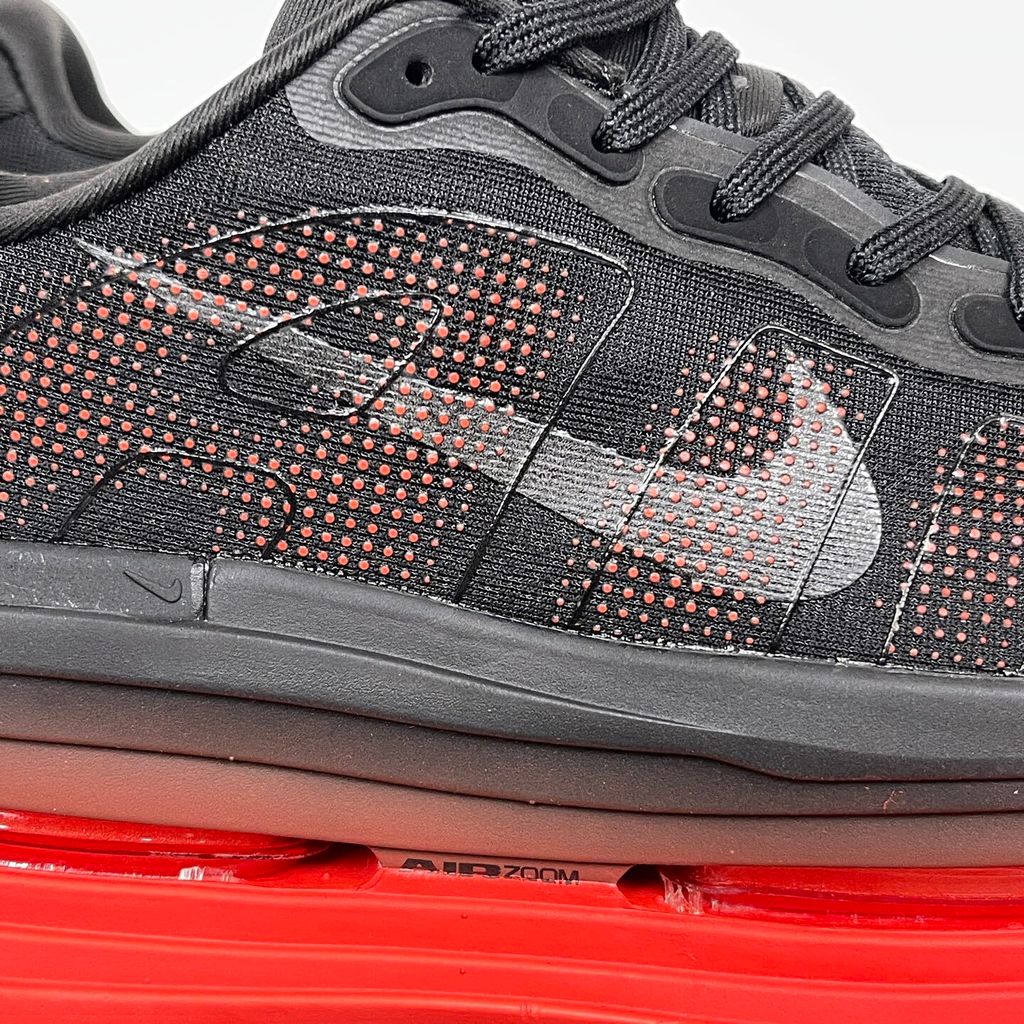 Side profile of the Nike Vomero Premium sneaker featuring a stealthy black mesh upper with oversized 'AIR' branding, and a massive gradient platform midsole transitioning from black to bright crimson with exposed Zoom Air units.