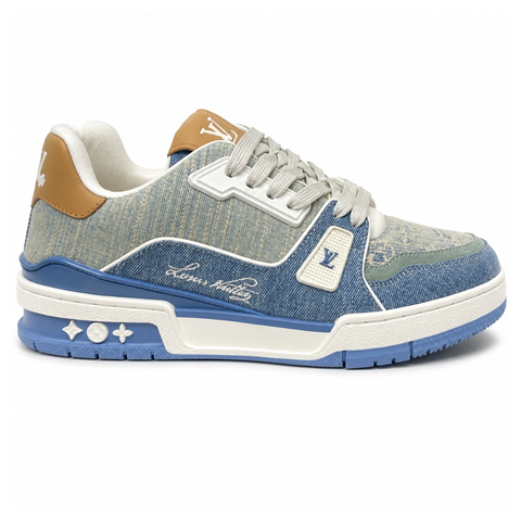 Side profile of the Tyler, the Creator x Louis Vuitton LV Trainer sneaker, showcasing a mix of light grey and blue denim paneling, a contrasting brown leather heel tab, the LV Initials logo, and custom cursive Louis Vuitton embroidery on the lateral side.