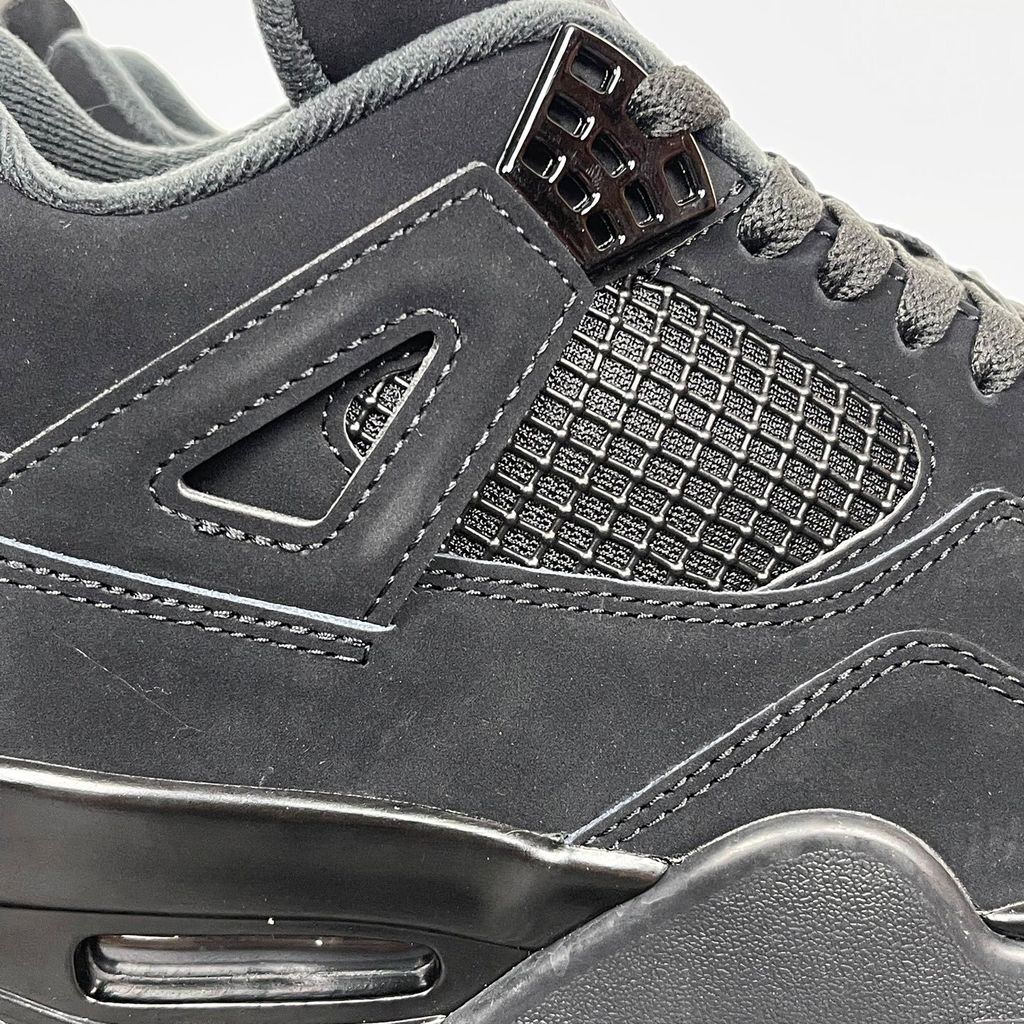 Side profile of the Air Jordan 4 Retro 'Black Cat' (2020) featuring a stealthy, monochromatic all-black nubuck suede upper, matching black mesh netting, matte wing eyelets, and a black midsole with a visible Air unit.  Product Description