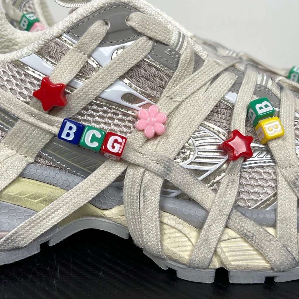 Side profile of the Balenciaga 3XL Extreme Lace sneaker in an eggshell and multicolor palette, highlighting the heavily distressed chunky rubber sole, worn-in mesh upper, and the signature extreme wraparound laces covering the toe box and midsole.
