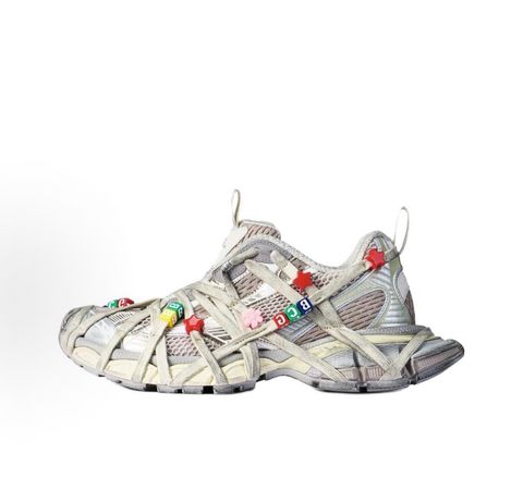 Side profile of the Balenciaga 3XL Extreme Lace sneaker in an eggshell and multicolor palette, highlighting the heavily distressed chunky rubber sole, worn-in mesh upper, and the signature extreme wraparound laces covering the toe box and midsole.