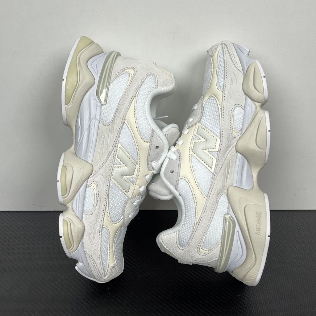 Side profile of the New Balance 9060 sneaker in a creamy Angora and Sea Salt colorway, featuring a chunky sculpted ABZORB midsole, premium suede overlays, a breathable mesh base, and the signature 'N' logo.