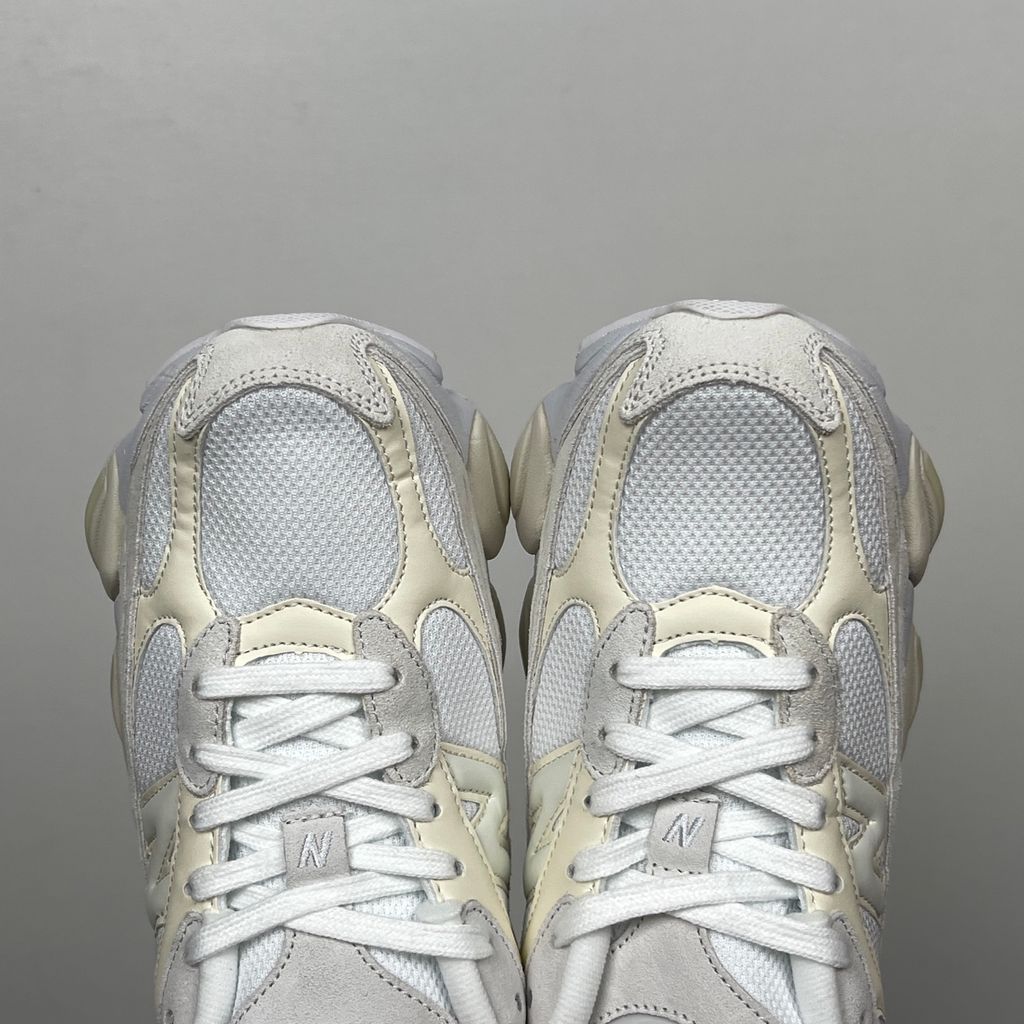Side profile of the New Balance 9060 sneaker in a creamy Angora and Sea Salt colorway, featuring a chunky sculpted ABZORB midsole, premium suede overlays, a breathable mesh base, and the signature 'N' logo.