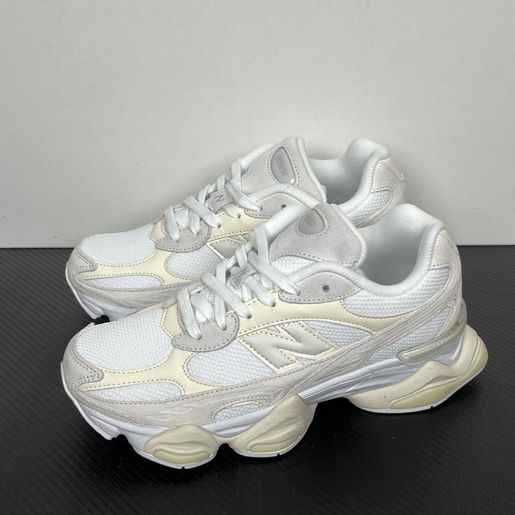 Side profile of the New Balance 9060 sneaker in a creamy Angora and Sea Salt colorway, featuring a chunky sculpted ABZORB midsole, premium suede overlays, a breathable mesh base, and the signature 'N' logo.