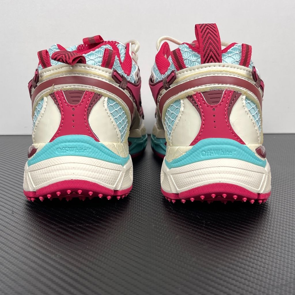 Side profile of the Off-White Be Right sneaker in a vibrant rose, burgundy, and light blue colorway, featuring a complex mesh upper, the signature Off-White arrow overlays, a matching pink zip-tie tag, and a chunky segmented midsole.