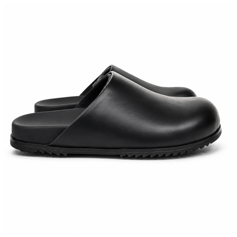 Side profile of the Rick Owens Mule Granola in smooth black leather, featuring a minimalist slip-on silhouette, an exaggerated rounded toe box, and a signature dark jagged rubber outsole.