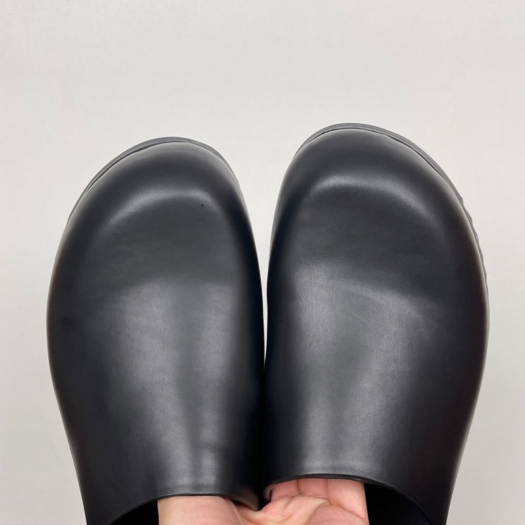 Side profile of the Rick Owens Mule Granola in smooth black leather, featuring a minimalist slip-on silhouette, an exaggerated rounded toe box, and a signature dark jagged rubber outsole.