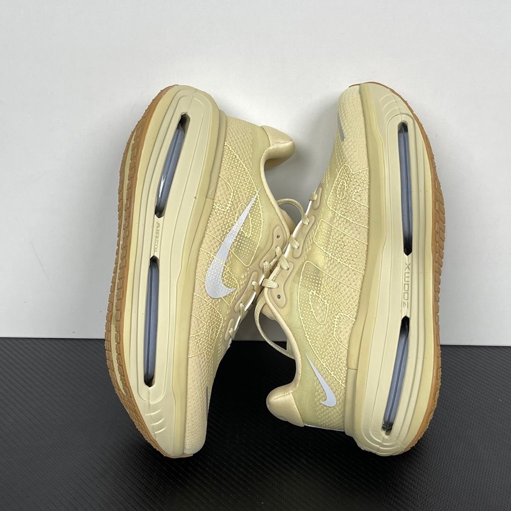 Side profile of the Nike Air Zoom Vomero Premium sneaker in a tonal Desert Khaki and Light Khaki colorway, featuring a complex layered upper of breathable mesh and premium suede overlays, resting on a chunky cushioned midsole.