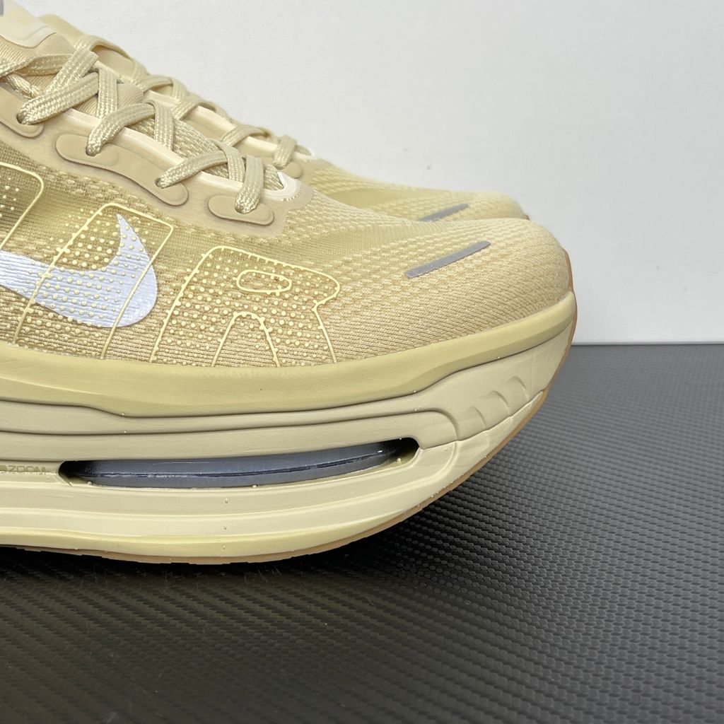 Side profile of the Nike Air Zoom Vomero Premium sneaker in a tonal Desert Khaki and Light Khaki colorway, featuring a complex layered upper of breathable mesh and premium suede overlays, resting on a chunky cushioned midsole.