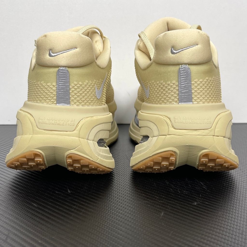 Side profile of the Nike Air Zoom Vomero Premium sneaker in a tonal Desert Khaki and Light Khaki colorway, featuring a complex layered upper of breathable mesh and premium suede overlays, resting on a chunky cushioned midsole.