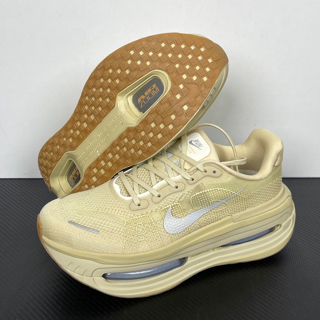Side profile of the Nike Air Zoom Vomero Premium sneaker in a tonal Desert Khaki and Light Khaki colorway, featuring a complex layered upper of breathable mesh and premium suede overlays, resting on a chunky cushioned midsole.