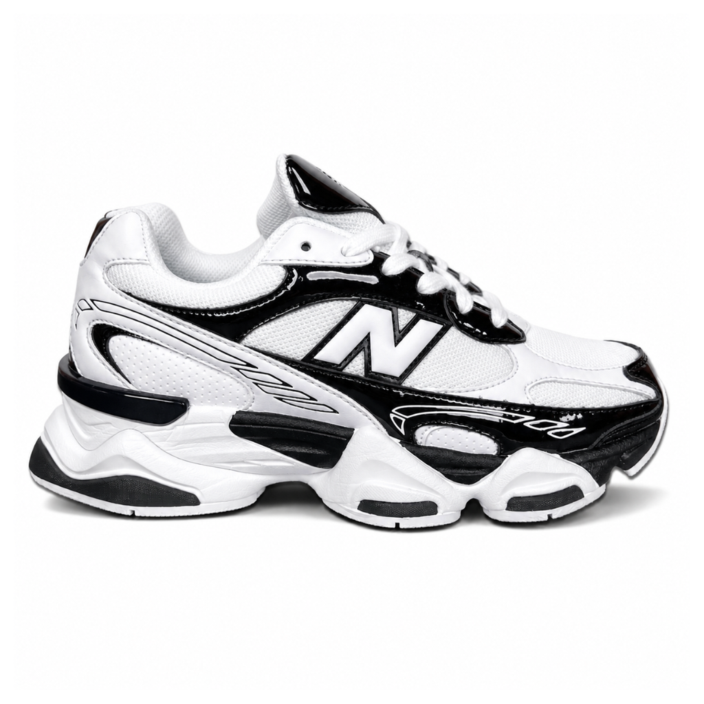 Side profile of the New Balance 9060 sneaker in a sleek black and white colorway, featuring a complex mixed-material upper of suede and mesh, a prominent contrasting 'N' logo, and a highly sculpted chunky midsole with distinctive pod detailing.